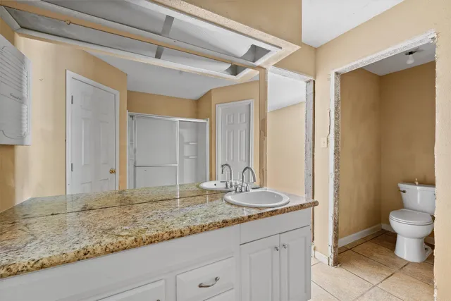 a bathroom with a granite countertop sink and a mirror