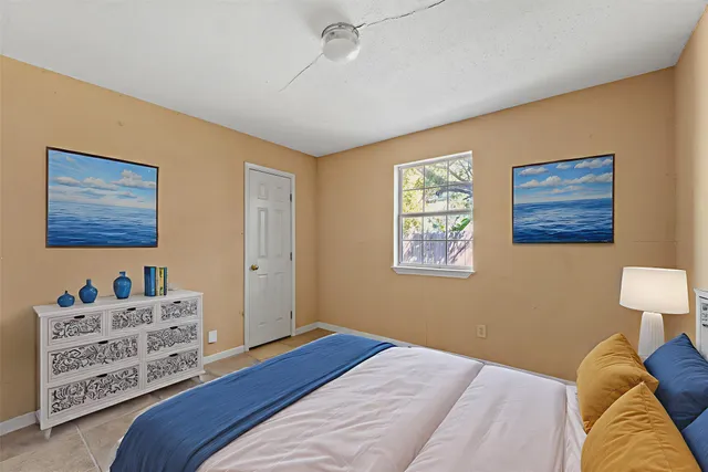 a bedroom with a bed and a lamp on dresser