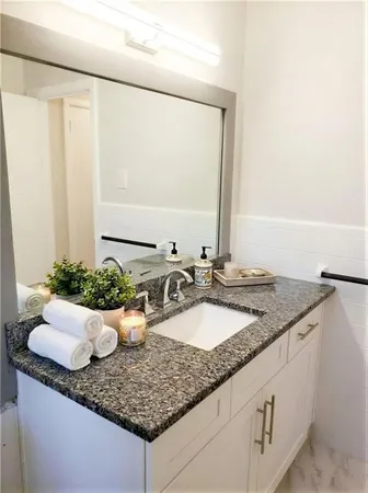 a bathroom with a granite countertop sink and a mirror
