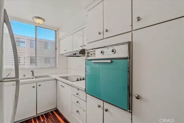 a kitchen with white cabinets and white appliances