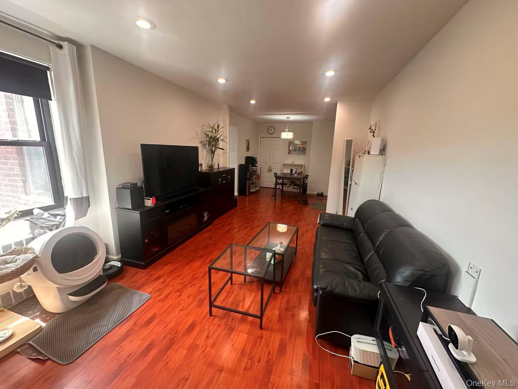 139-15 28th Road, Unit 6G Queens, NY 11354 - Photo 2 of 20 a living room with furniture and a flat screen tv