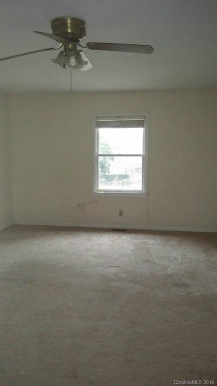 934 State Rd S-28-818 Elgin, SC 29045 - Photo 8 of 15 an empty room with a chandelier fan and windows