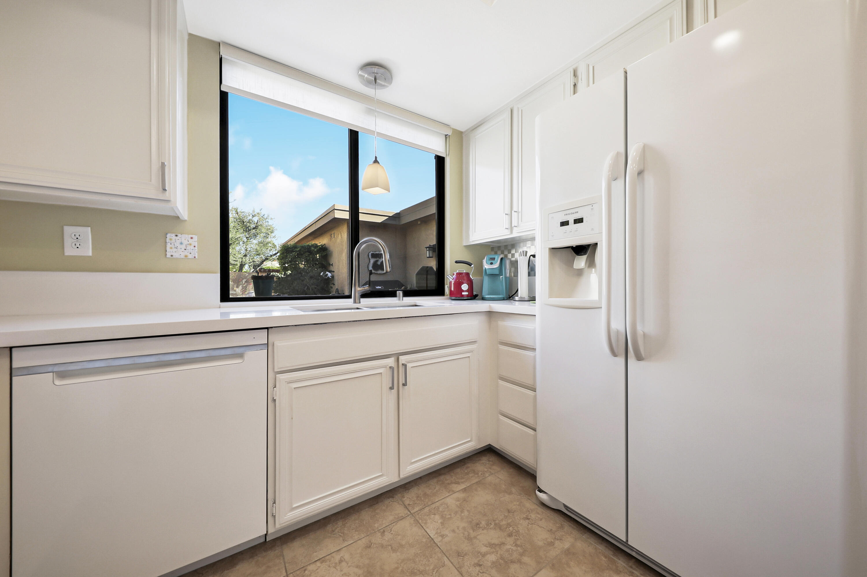 35 La Ronda Drive Rancho Mirage, CA 92270 - Photo 4 of 54 a kitchen with white cabinets and a window