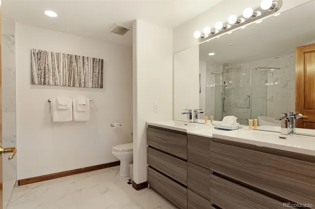a bathroom with a double vanity sink toilet and a mirror