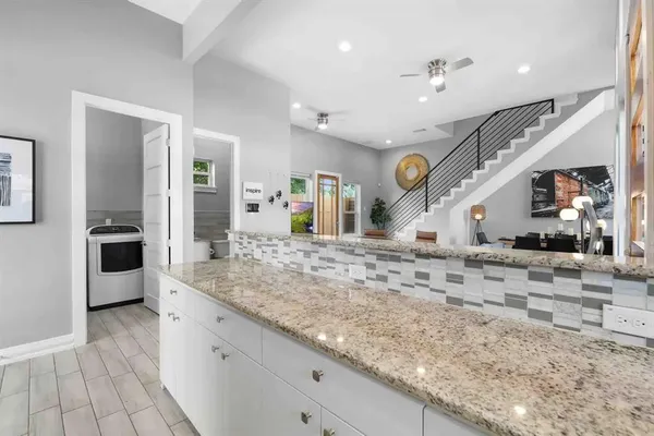 a view of a kitchen with kitchen island a counter top space a sink stainless steel appliances and cabinets
