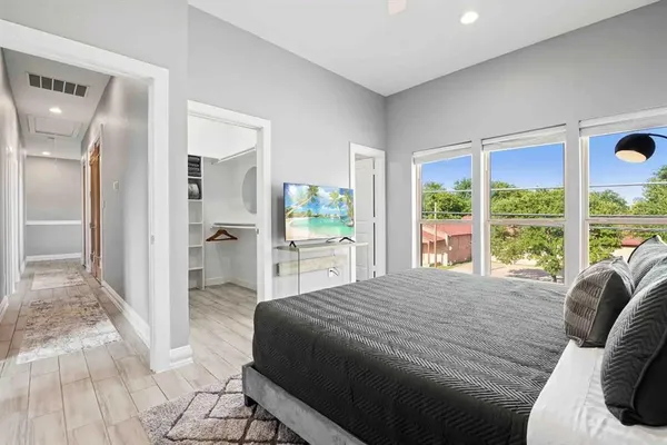 a view of a bedroom with a bed and wooden floor