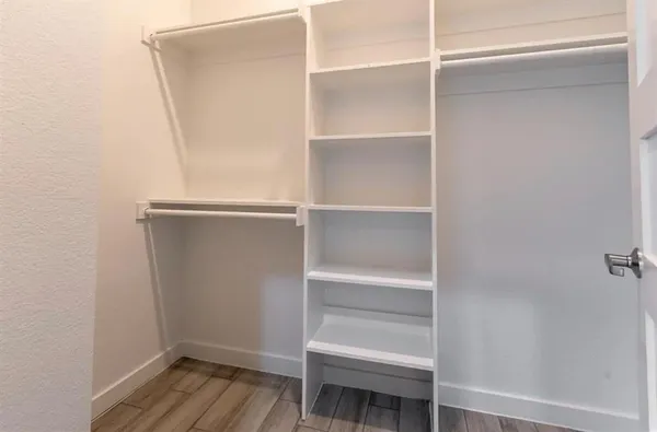 a view of walk in closet with empty racks