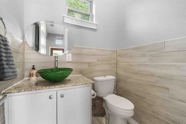 a bathroom with a granite countertop toilet sink and mirror