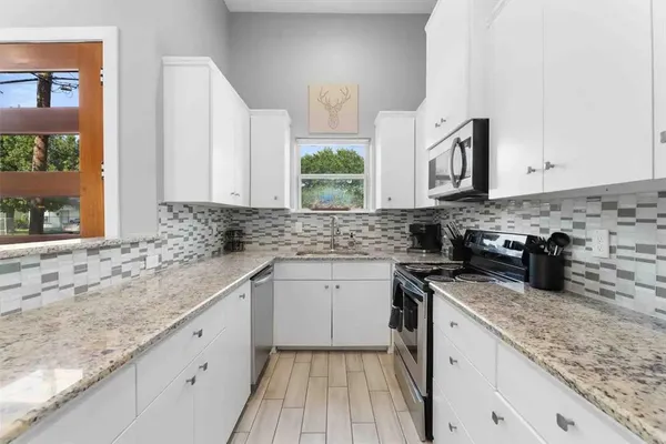 a kitchen with stainless steel appliances granite countertop a sink stove and cabinets