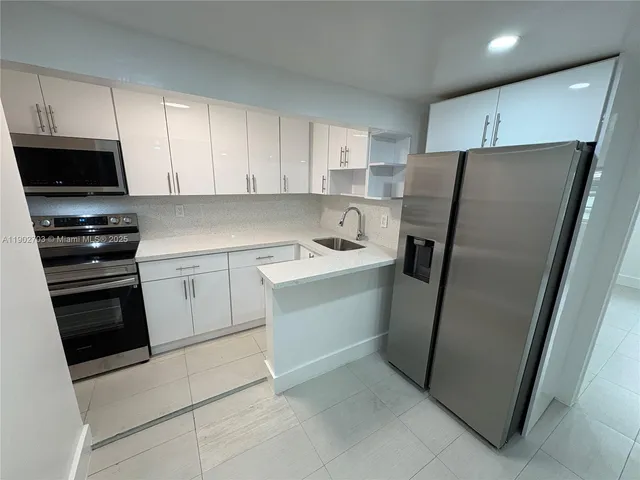 a kitchen with a refrigerator sink and cabinets