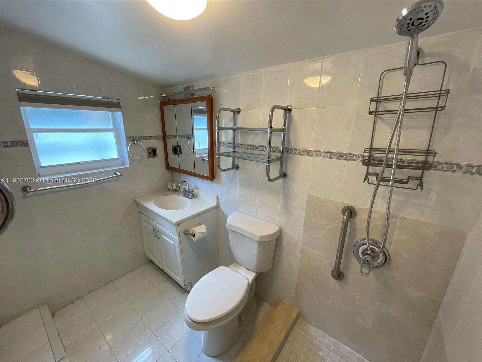 3157 Southwest 17th Street, Unit B Miami, FL 33145 - Photo 9 of 18 a bathroom with a toilet sink and mirror