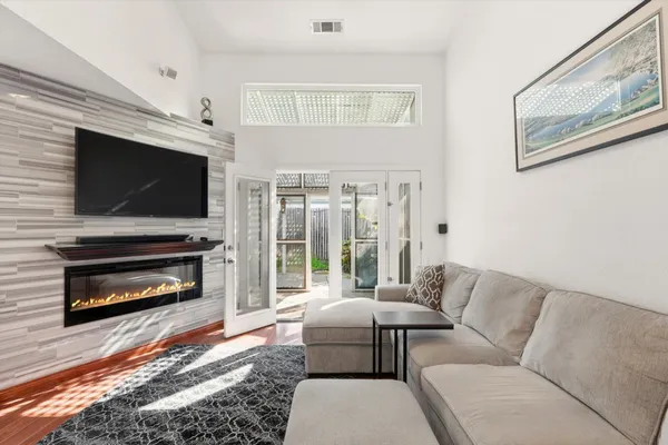 a living room with furniture a flat screen tv and a fireplace