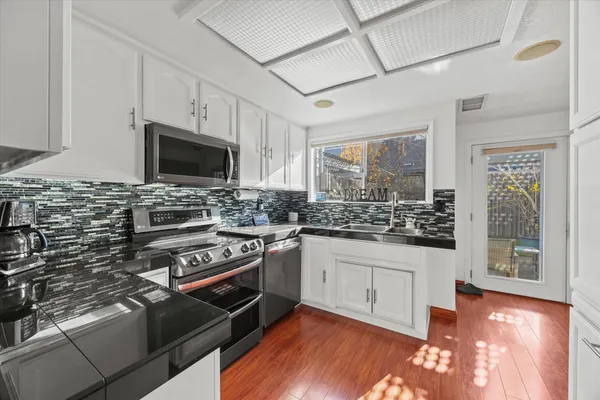 a kitchen with granite countertop a stove and a sink