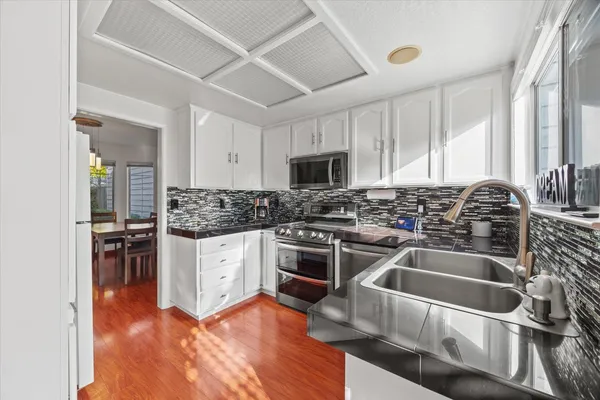 a kitchen with granite countertop a sink and steel appliances