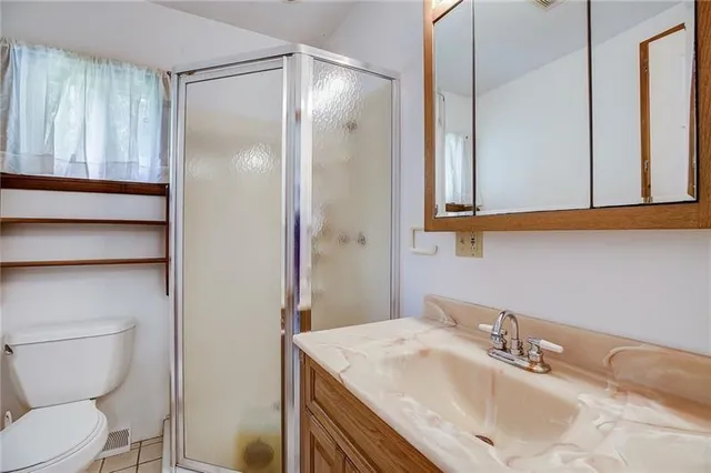 a bathroom with a sink toilet vanity and shower
