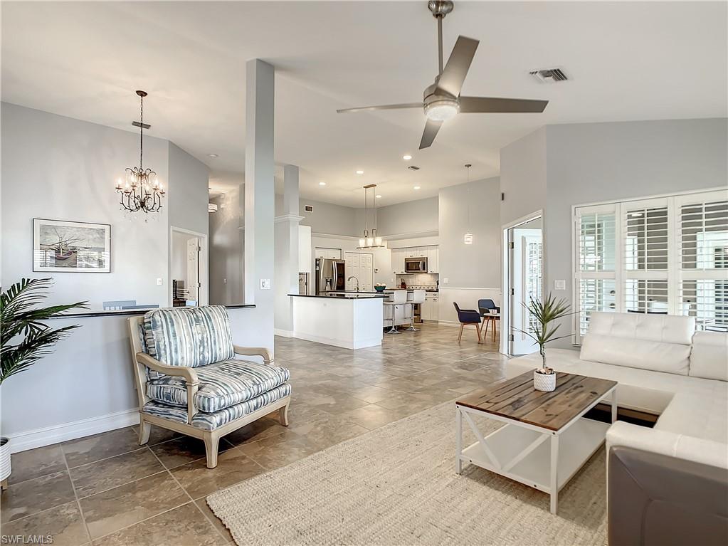 7858 Gardner Drive Naples, FL 34109 - Photo 13 of 35 a living room with furniture and a chandelier