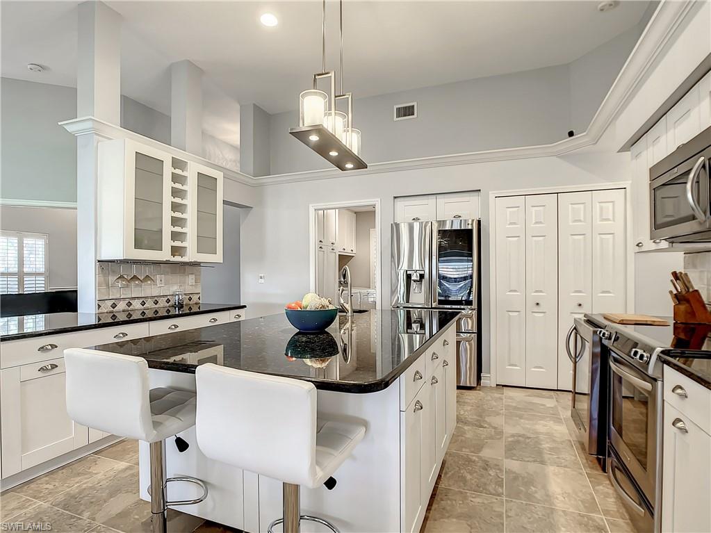 7858 Gardner Drive Naples, FL 34109 - Photo 15 of 35 a kitchen with a sink stove and refrigerator