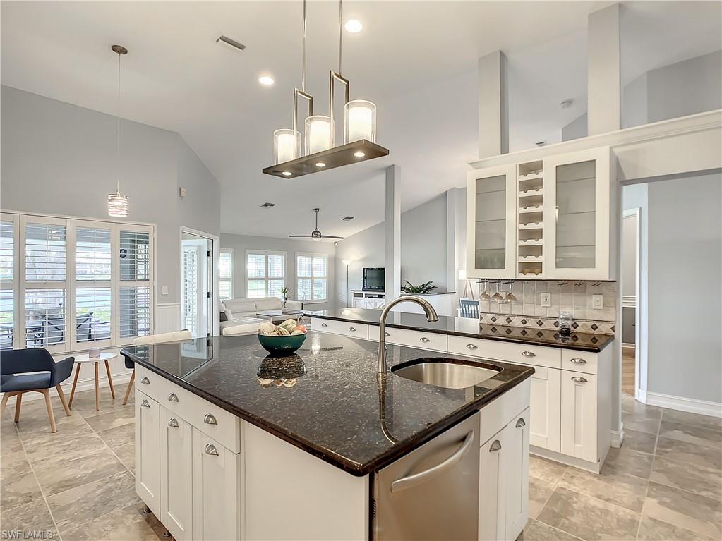 7858 Gardner Drive Naples, FL 34109 - Photo 16 of 35 a kitchen with center island a sink stainless steel appliances and windows