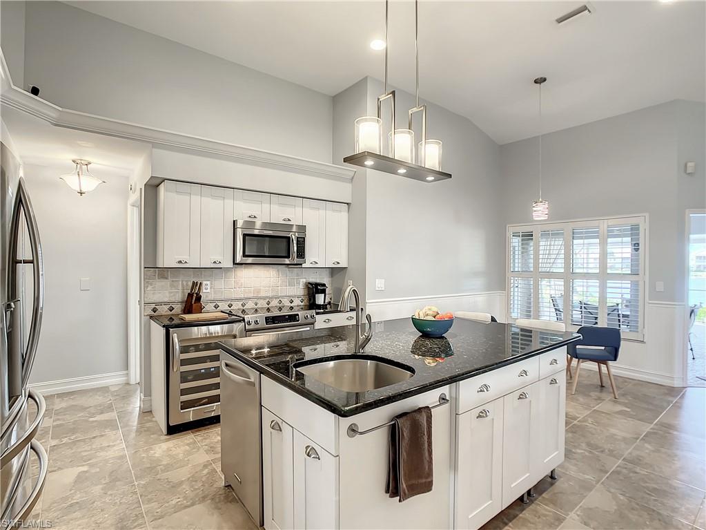 7858 Gardner Drive Naples, FL 34109 - Photo 17 of 35 a kitchen with stainless steel appliances granite countertop a sink stove and refrigerator