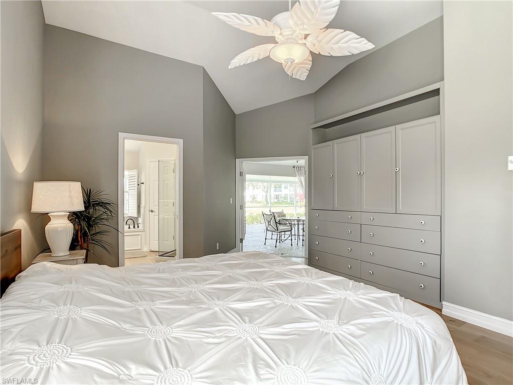 7858 Gardner Drive Naples, FL 34109 - Photo 24 of 35 a bedroom with a large bed and a chandelier