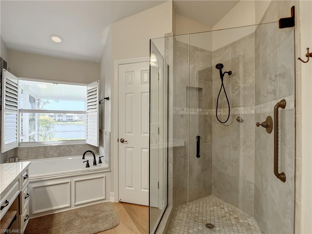 7858 Gardner Drive Naples, FL 34109 - Photo 26 of 35 a bathroom with a tub a sink a window and a shower
