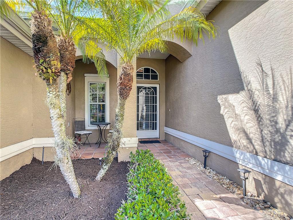 7858 Gardner Drive Naples, FL 34109 - Photo 8 of 35 a front view of a house with garden