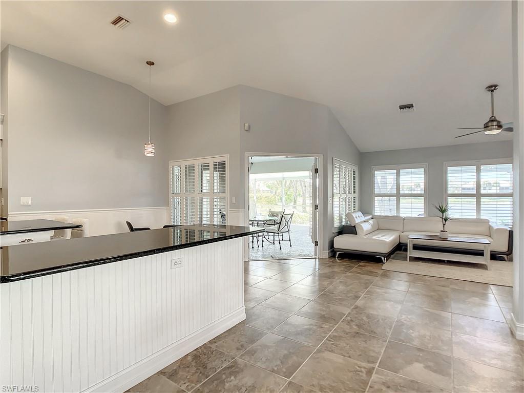 7858 Gardner Drive Naples, FL 34109 - Photo 10 of 35 a large white kitchen with a large window and couch