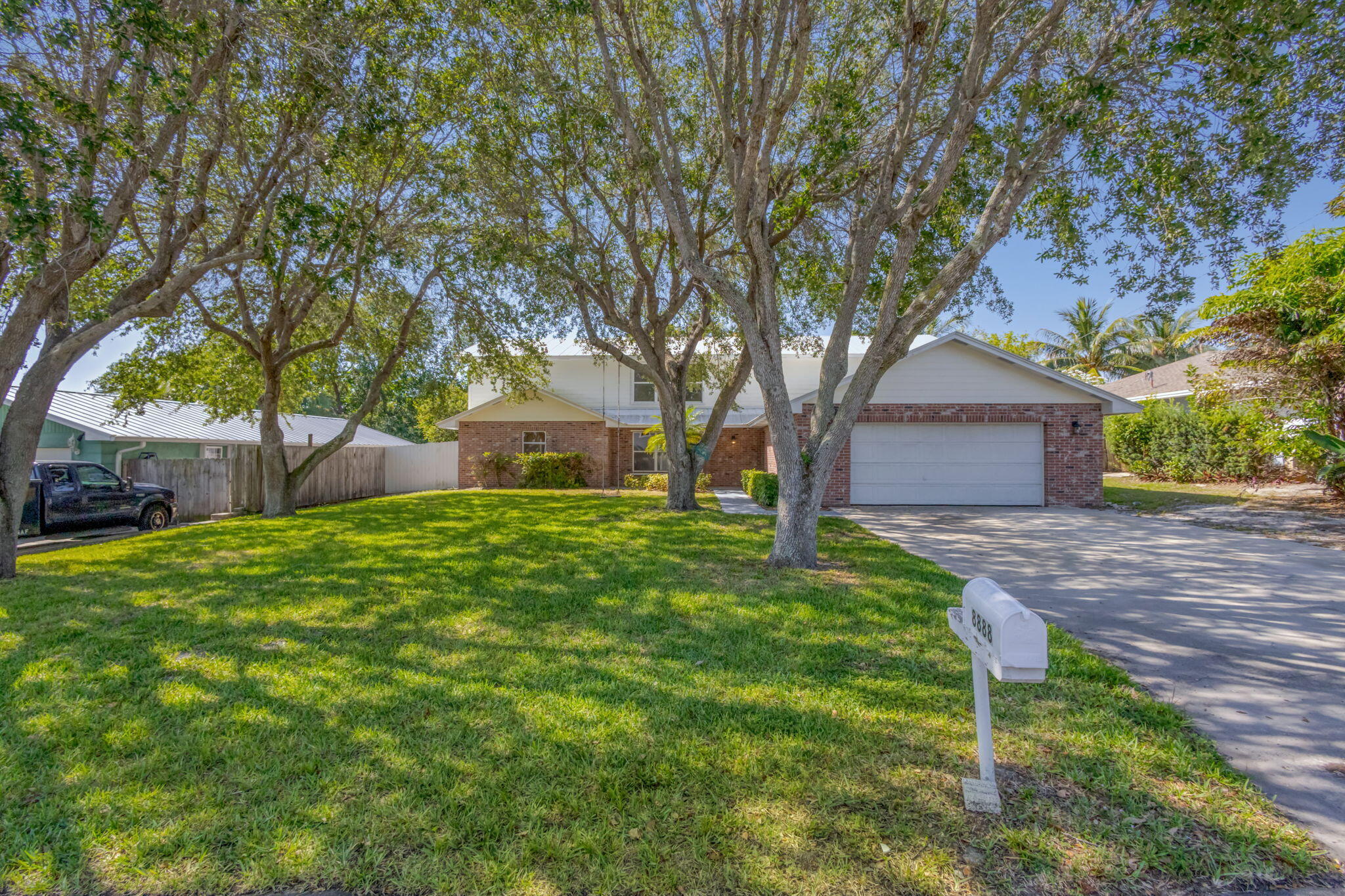 8888 Southeast Colony Street Hobe Sound, FL 33455 - Photo 1 of 69 a front view of a house with garden