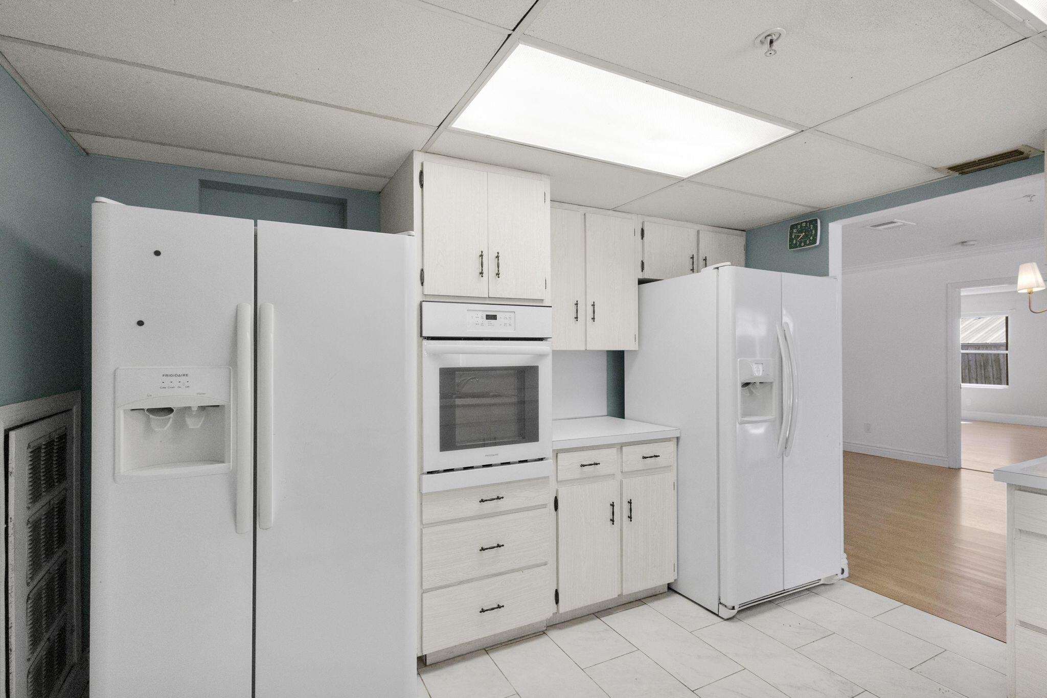 8888 Southeast Colony Street Hobe Sound, FL 33455 - Photo 13 of 69 a kitchen with white cabinets and white stainless steel appliances
