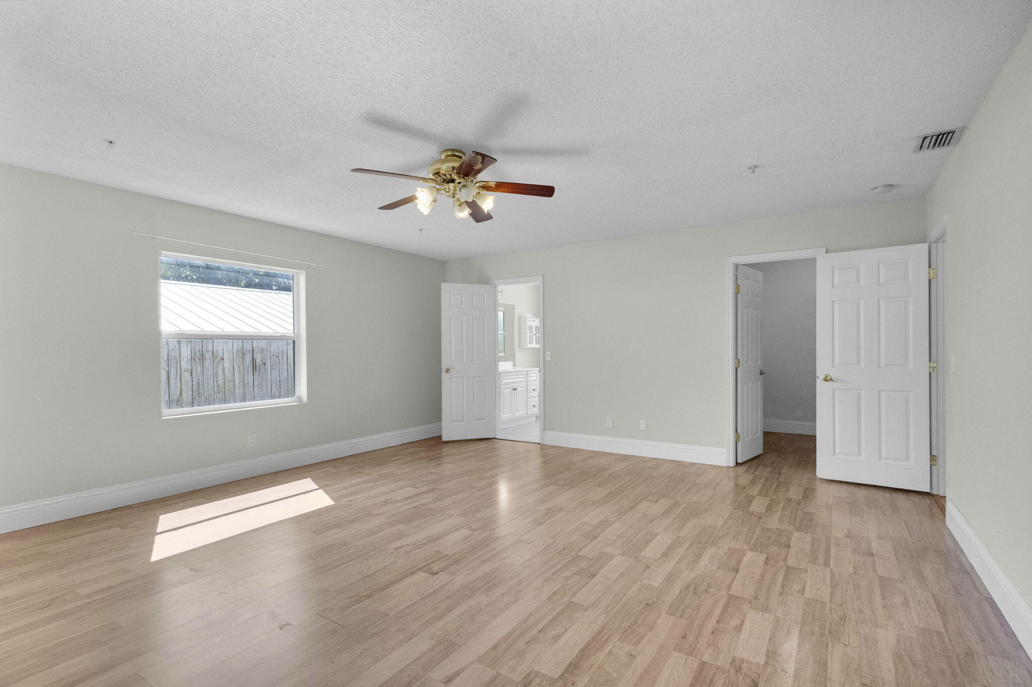 8888 Southeast Colony Street Hobe Sound, FL 33455 - Photo 21 of 69 a view of an empty room with a window and wooden floor