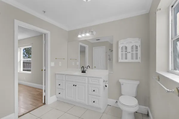 a bathroom with a toilet a sink a mirror a bathtub and vanity