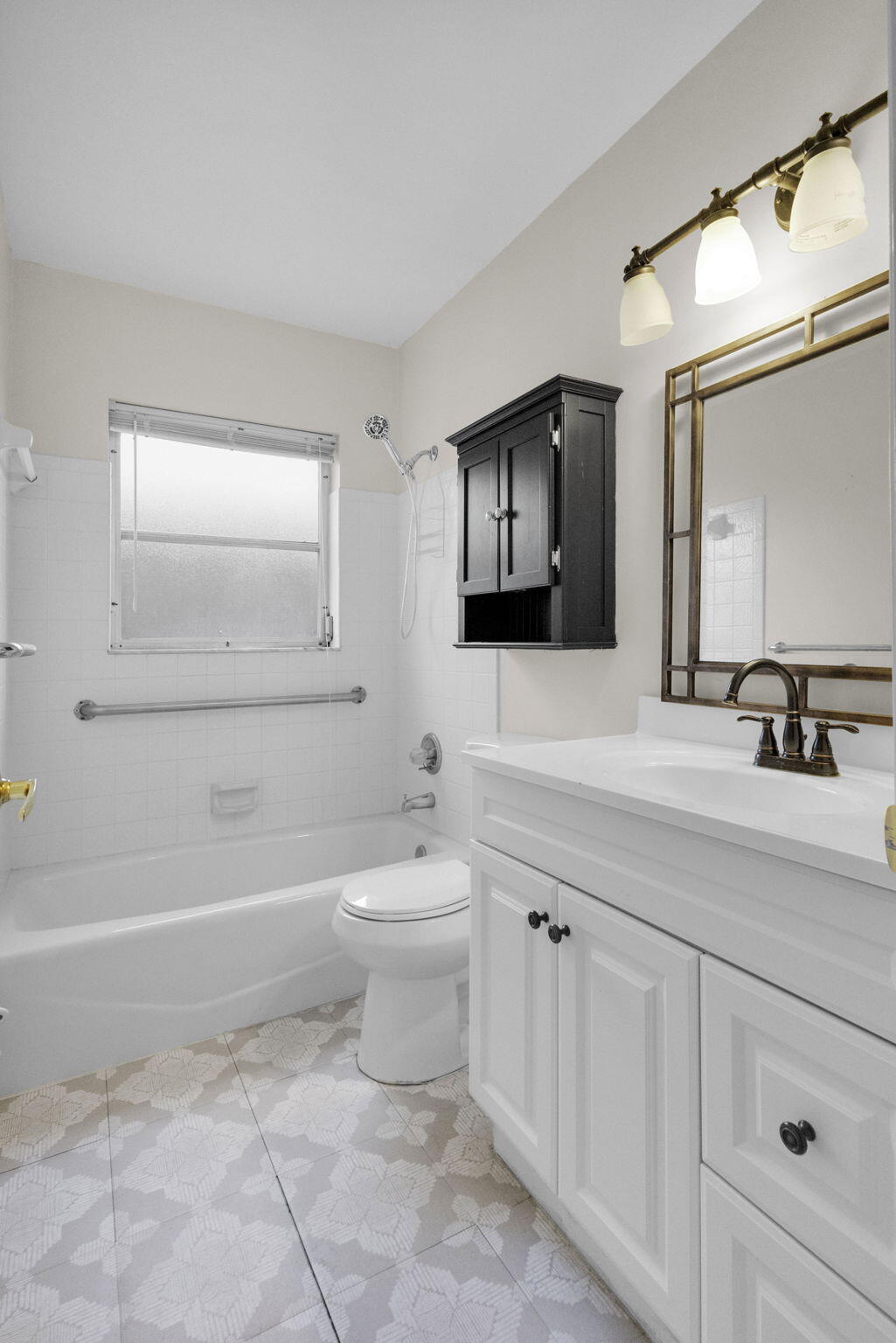 8888 Southeast Colony Street Hobe Sound, FL 33455 - Photo 30 of 69 a bathroom with a toilet a sink a mirror a bathtub and vanity