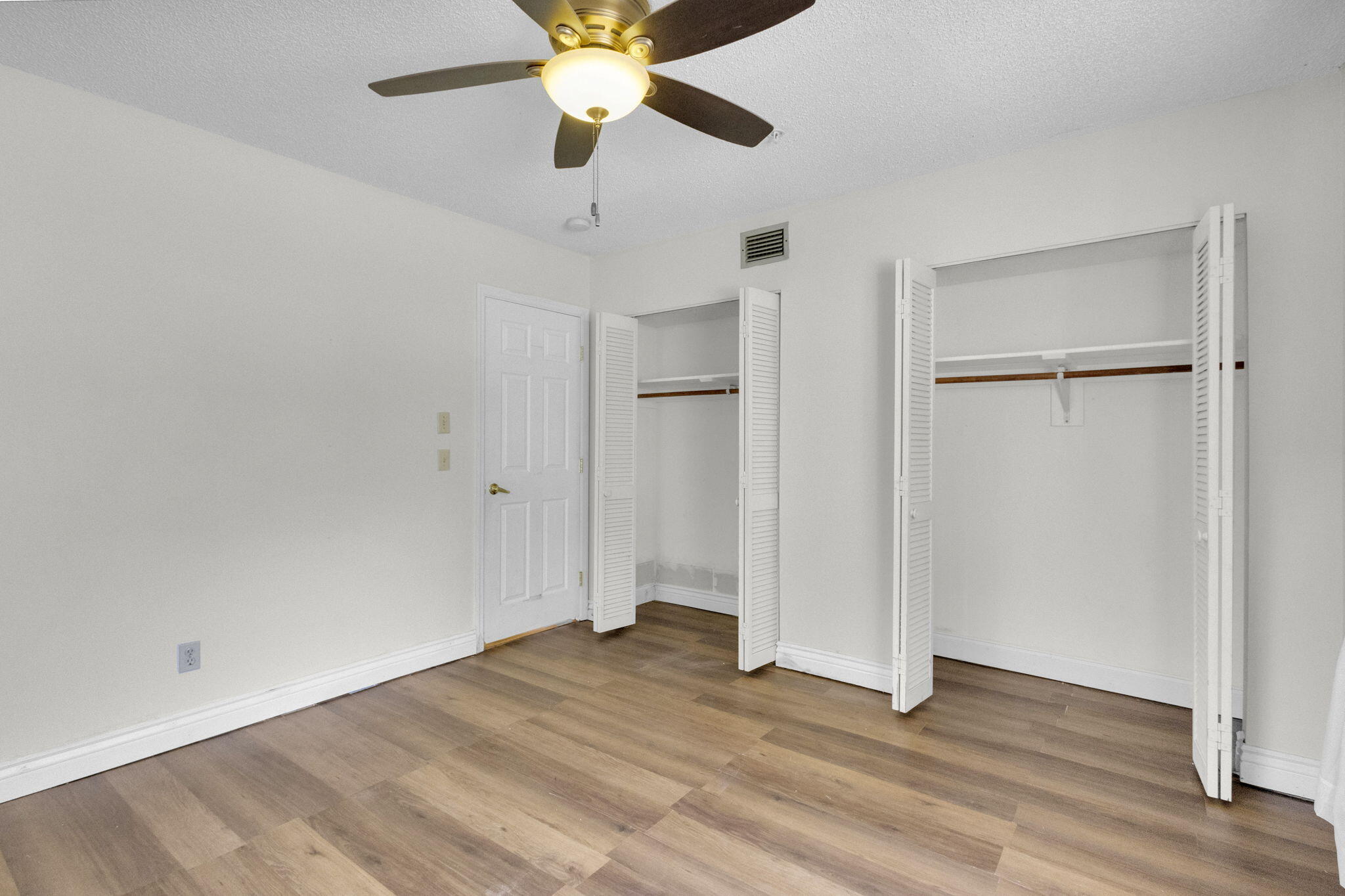 8888 Southeast Colony Street Hobe Sound, FL 33455 - Photo 32 of 69 an empty room with wooden floor closet and ceiling fan