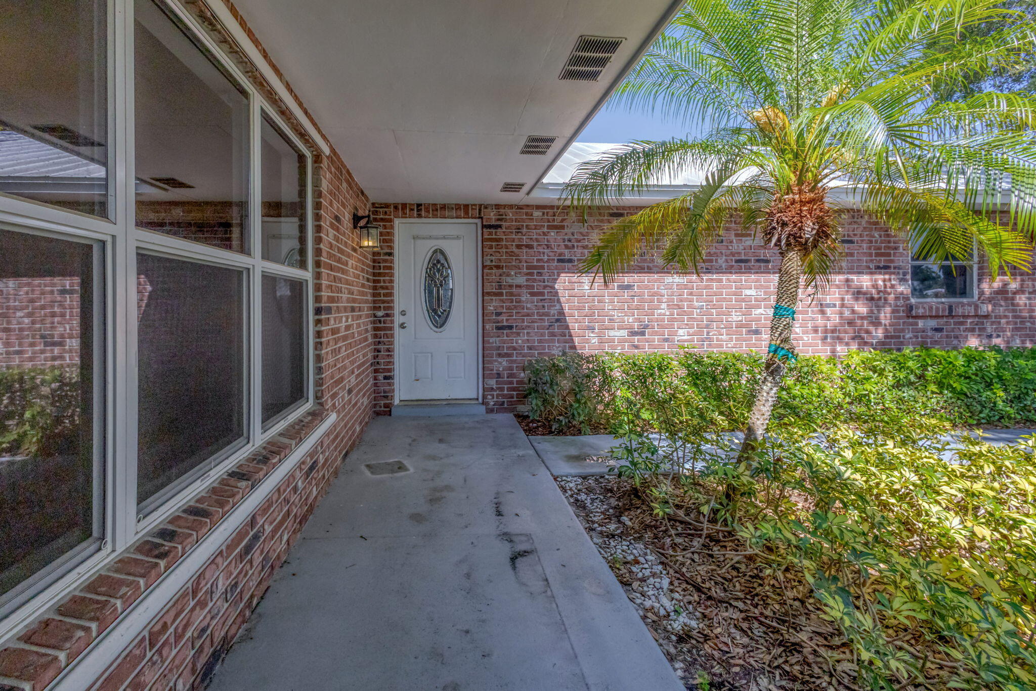 8888 Southeast Colony Street Hobe Sound, FL 33455 - Photo 5 of 69 a view of a pathway along the house