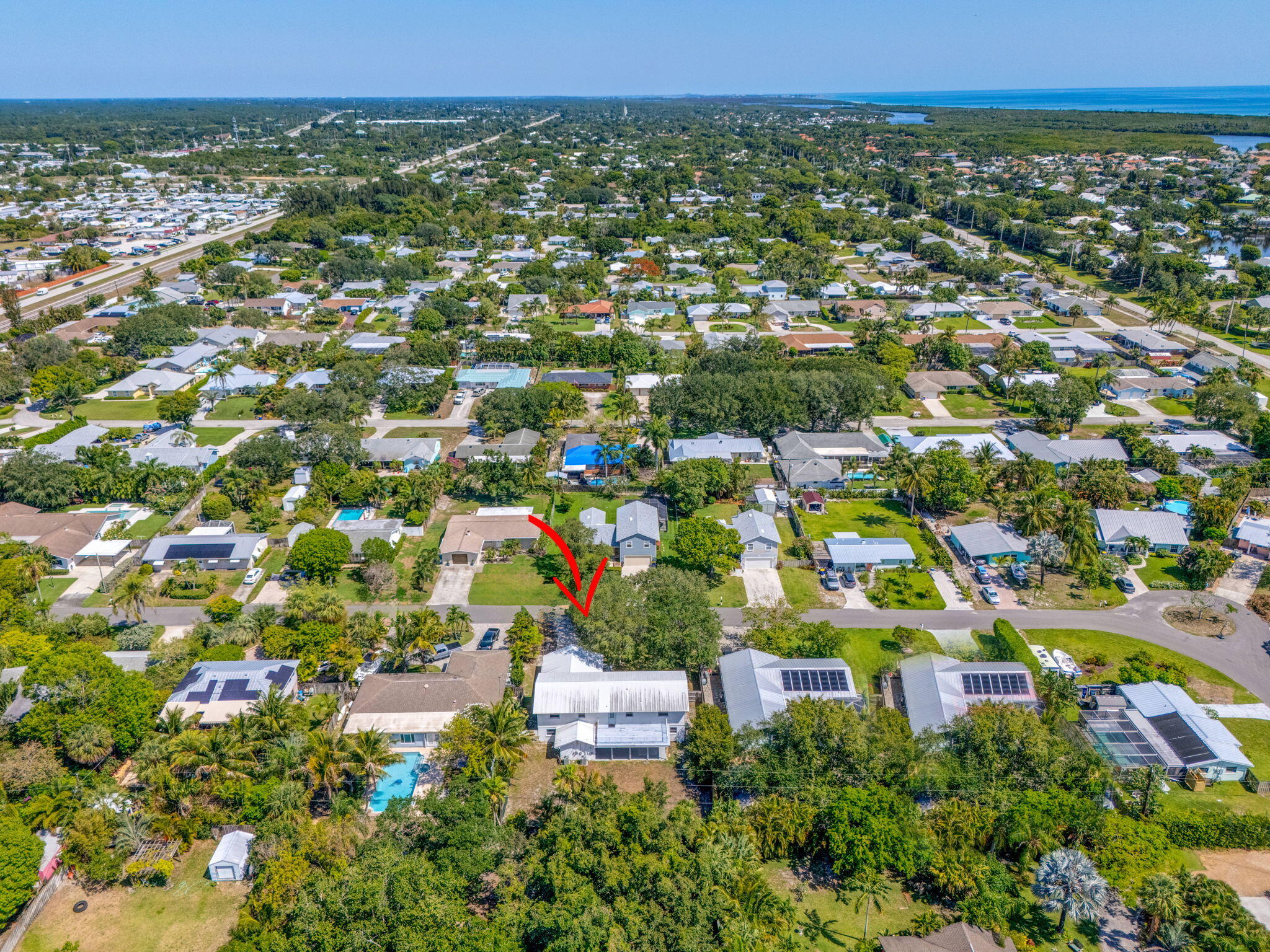 8888 Southeast Colony Street Hobe Sound, FL 33455 - Photo 67 of 69 an aerial view of residential houses with outdoor space and trees
