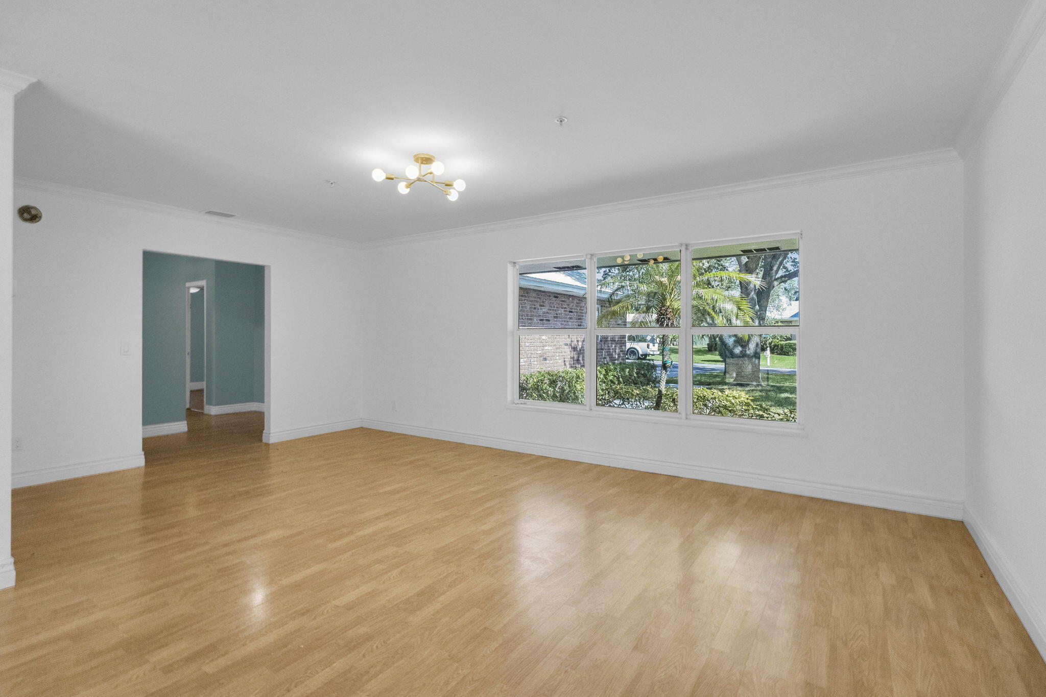 8888 Southeast Colony Street Hobe Sound, FL 33455 - Photo 8 of 69 a view of an empty room with wooden floor and a window