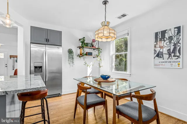 a view of a dining room with furniture a chandelier and wooden floor