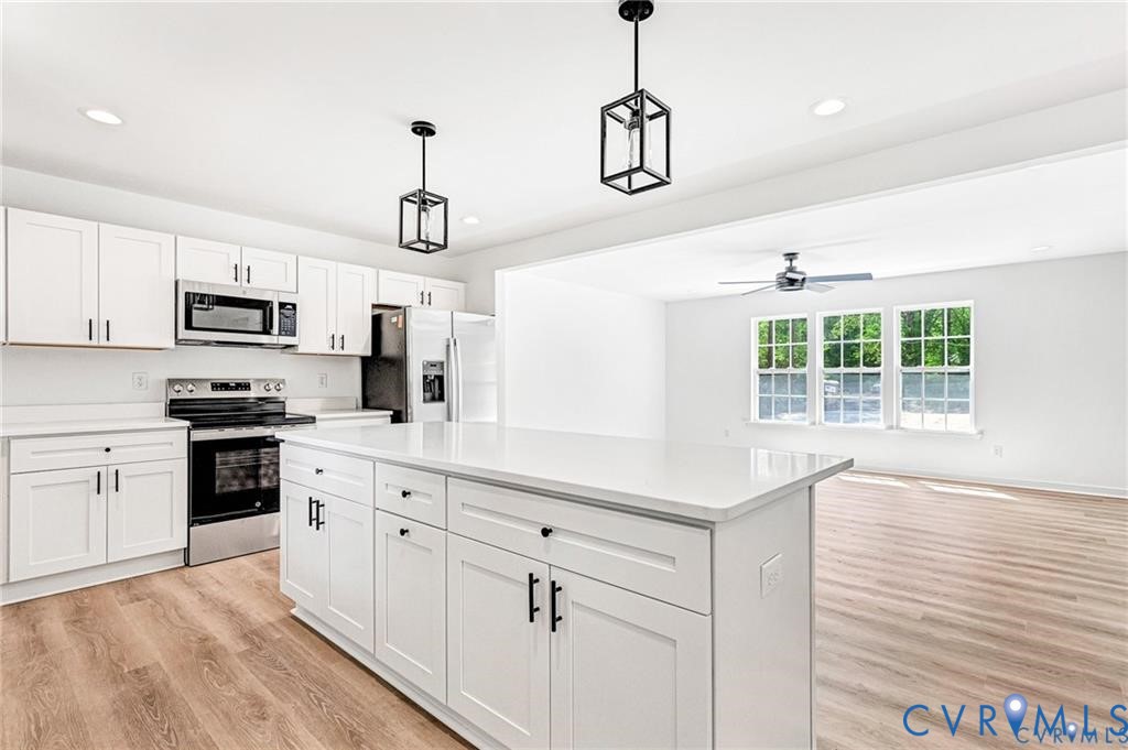512 Freedom Drive Ruther Glen, VA 22546 - Photo 11 of 36 a kitchen with kitchen island white cabinets and white appliances