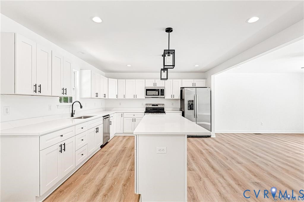 512 Freedom Drive Ruther Glen, VA 22546 - Photo 13 of 36 a kitchen with stainless steel appliances kitchen island granite countertop a sink and dishwasher a refrigerator with white cabinets