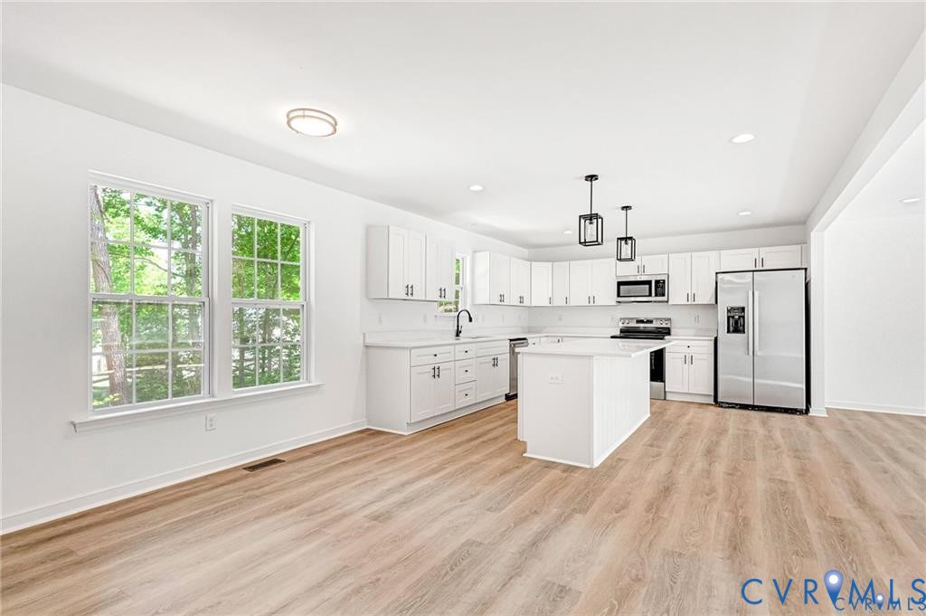 512 Freedom Drive Ruther Glen, VA 22546 - Photo 17 of 36 a kitchen with white cabinets and wooden floor