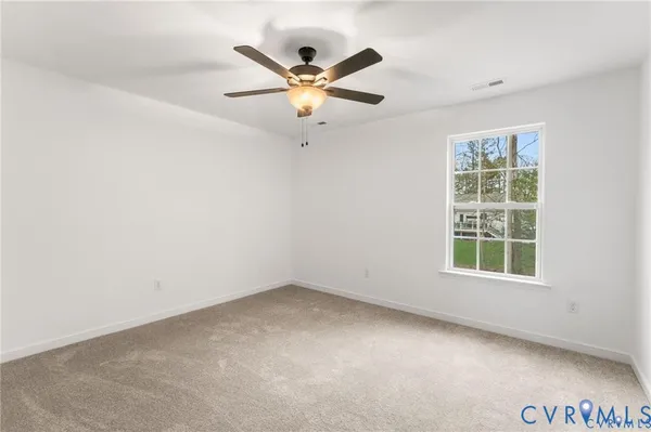 an empty room with window and ceiling fan