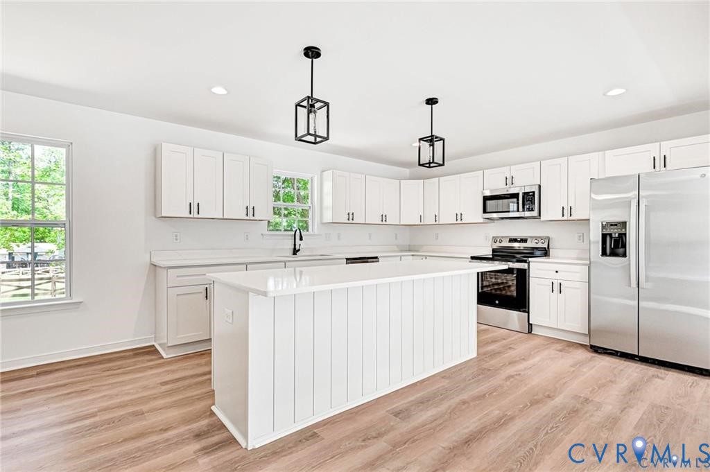 512 Freedom Drive Ruther Glen, VA 22546 - Photo 8 of 36 a kitchen with white cabinets and stainless steel appliances
