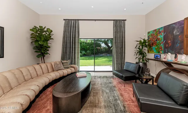 a living room with furniture plant and a large window