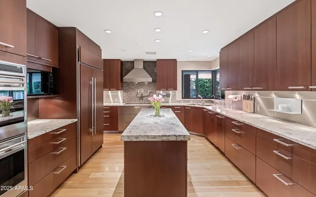 a kitchen with kitchen island granite countertop wooden cabinets a sink and a stove