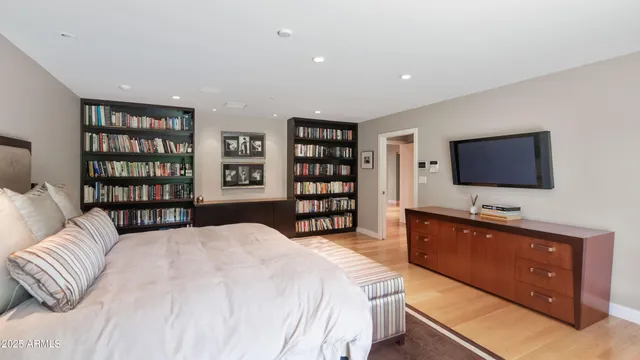 a spacious bedroom with a bed and a flat screen television