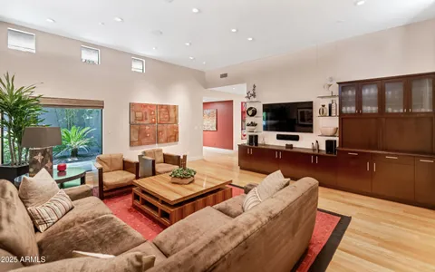a living room with furniture a large window and a flat screen tv