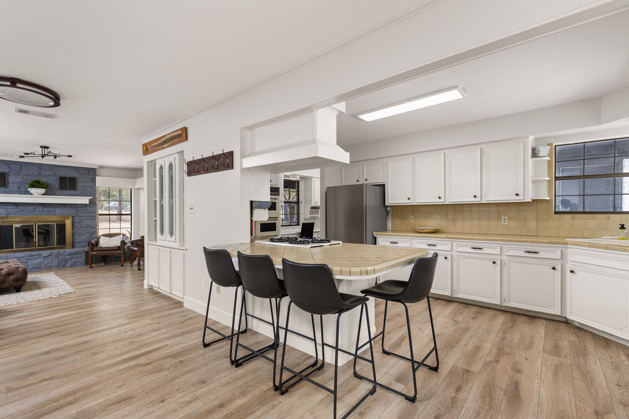 196 Willy Road Bastrop, TX 78602 - Photo 11 of 40 Gleaming wood-look floors anchor this open-concept kitchen featuring a tiled center island.