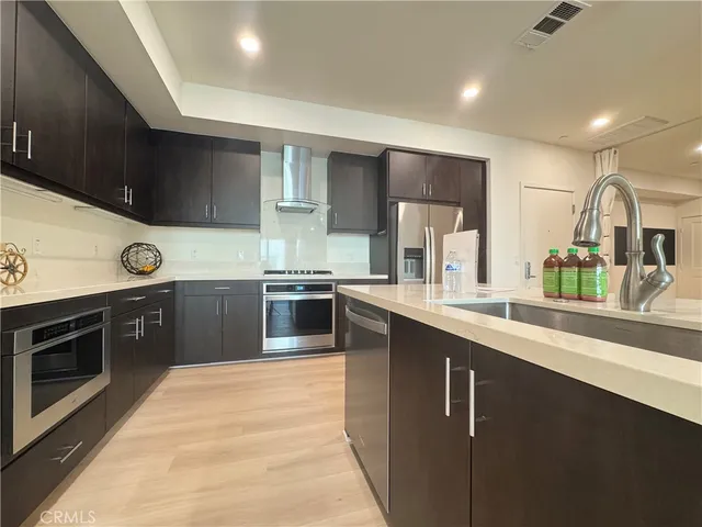 a kitchen with stainless steel appliances granite countertop a sink a stove and a refrigerator