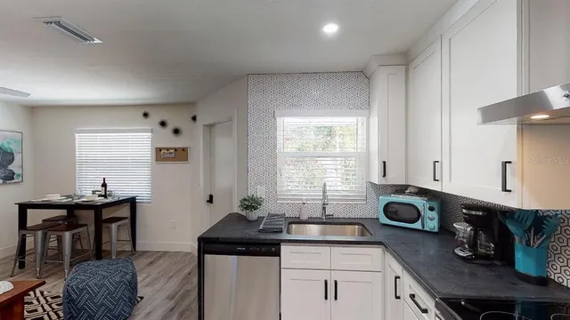 a kitchen with stainless steel appliances a sink a stove and a window