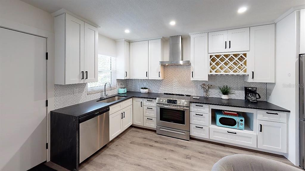 1912 Morrill Street, Unit LIME Sarasota, FL 34236 - Photo 22 of 34 a kitchen with stainless steel appliances granite countertop a stove a sink and a microwave